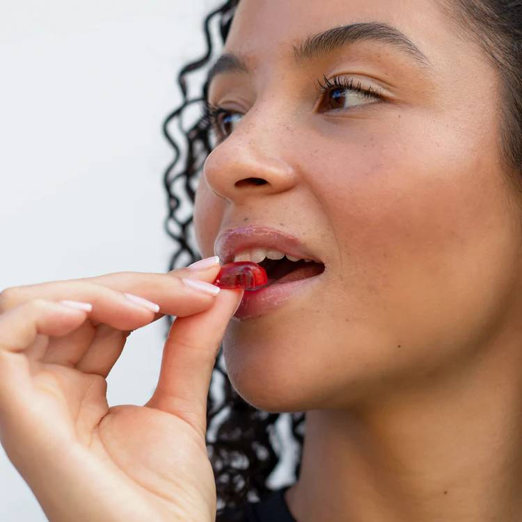 Kvinna som äter en vitamin gummie - bara en av produkterna inom träning och hälsa som Futurelab har.
